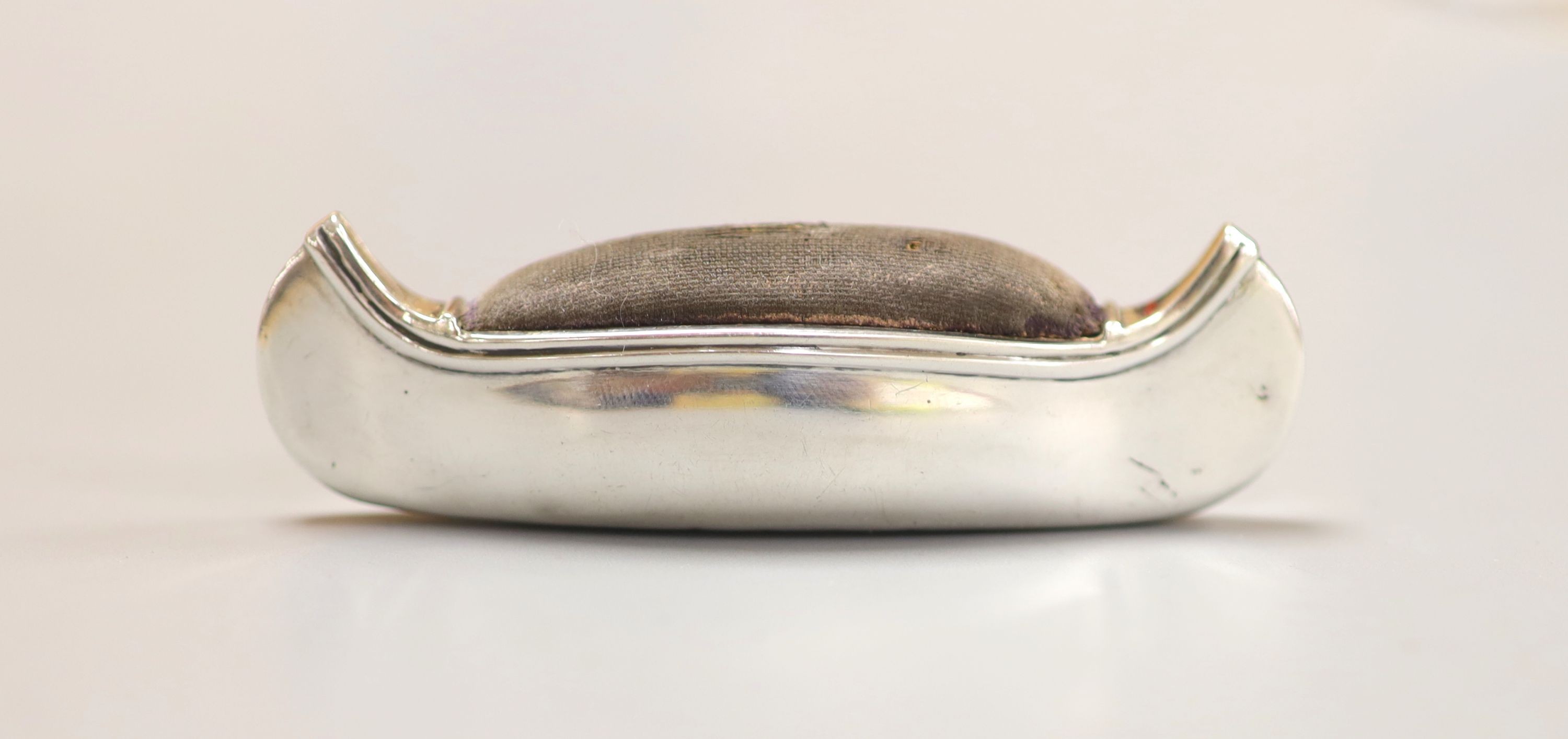 An Edwardian silver mounted pin cushion, modelled as a canoe, Cohen & Charles, Birmingham, 1906. 76mm.